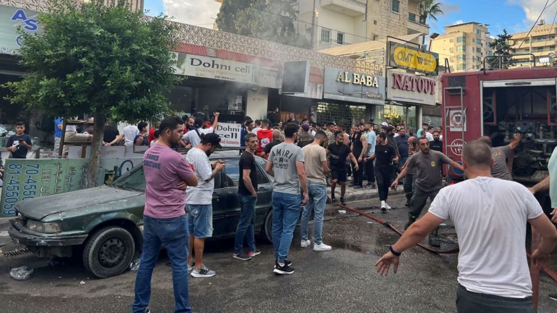 Los bomberos apagan las llamas y una multitud se reúne después de una explosión reportada en Saida, Líbano, el 18 de septiembre de 2024.