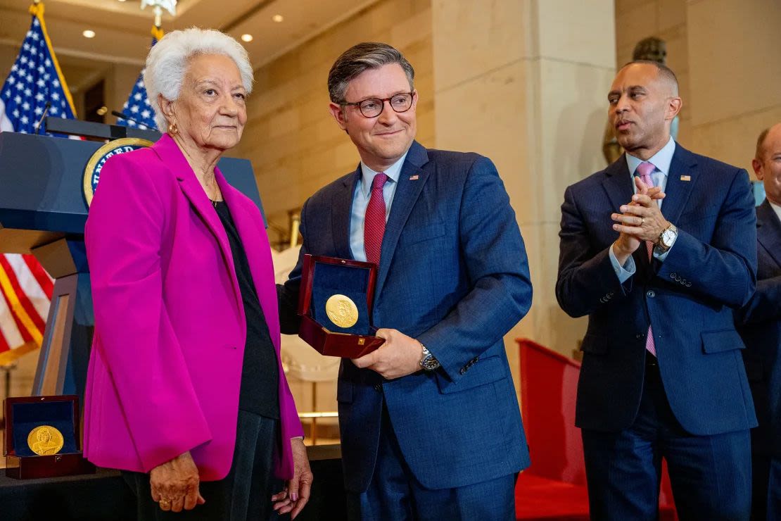 El líder de la minoría de la Cámara de Representantes, Hakeem Jeffries (derecha), aplaude mientras el presidente de la Cámara de Representantes, Mike Johnson, posa con Wanda Jackson (izquierda) al aceptar una Medalla de Oro del Congreso en nombre de Mary Jackson durante una ceremonia en el Capitolio el miércoles.