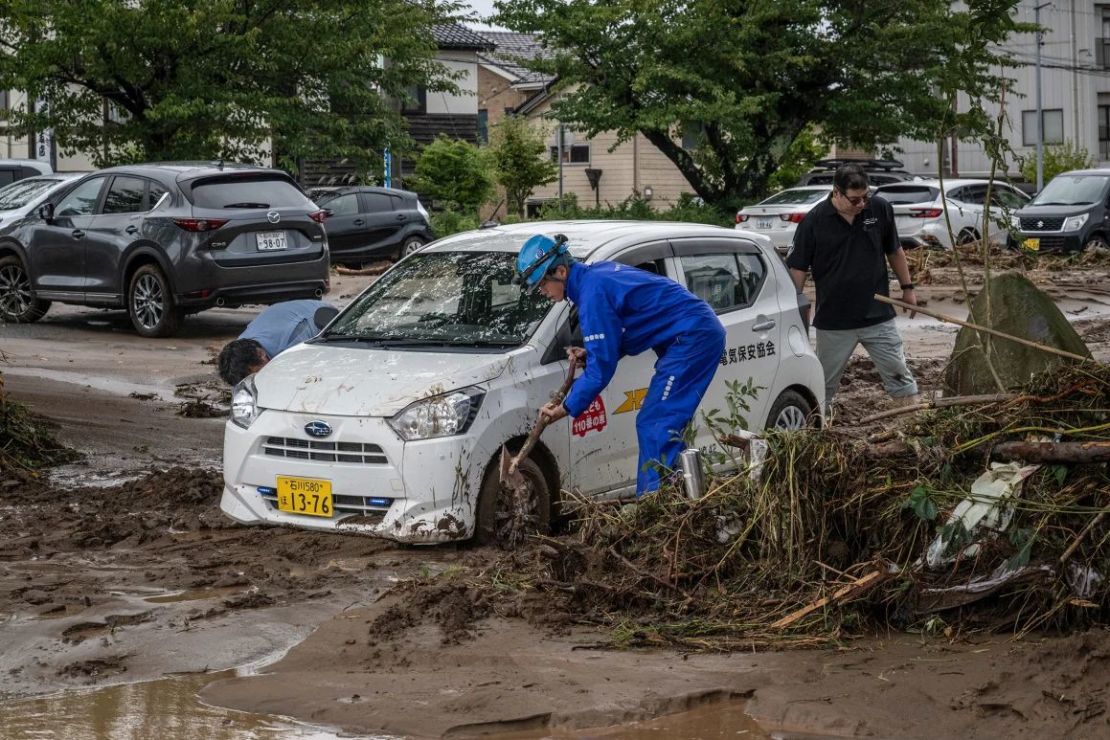 Personas retiran el barro para desalojar un automóvil luego de las inundaciones en la ciudad de Wajima, el 22 de septiembre de 2024. Crédito: Yuichi Yamazaki/AFP/Getty Images.