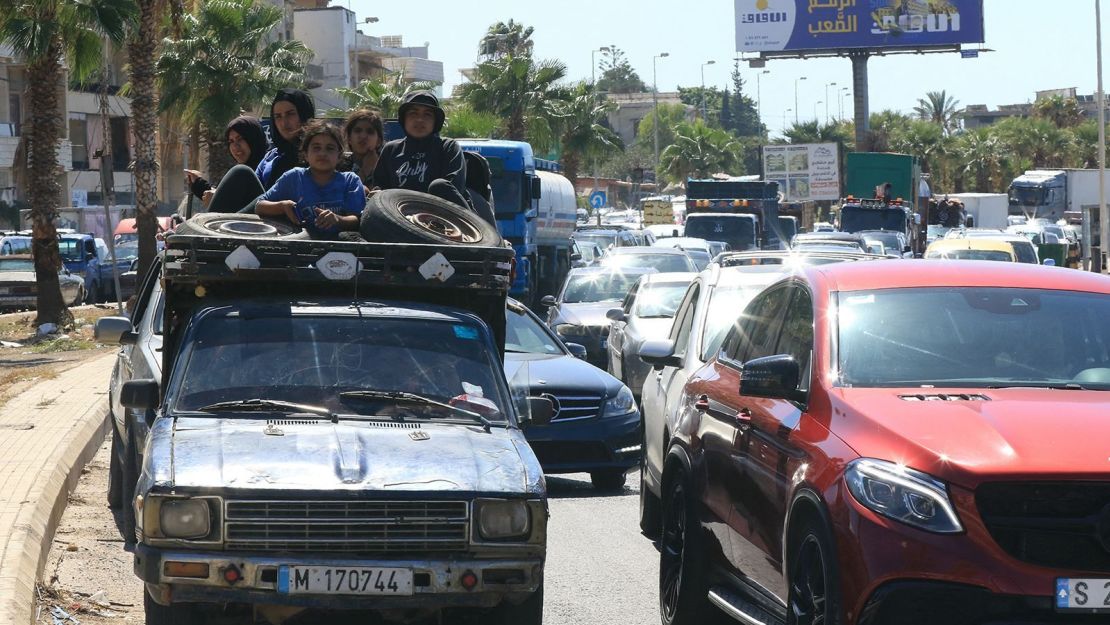 Una familia siria se sienta con sus pertenencias en la parte trasera de un camión mientras esperan en un atasco en la ciudad sureña de Sidón, Líbano, el 23 de septiembre de 2024.