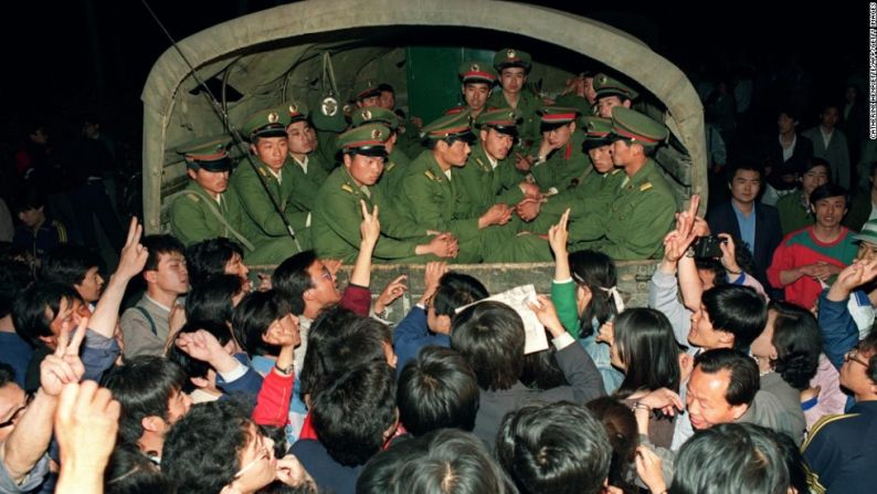 Con un signo de victoria, el 20 de mayo los manifestantes pro-democracia levantaron sus manos en signo de victoria mientras paran un camión militar lleno de militares que se dirigían hacia la Plaza de Tiananmén.