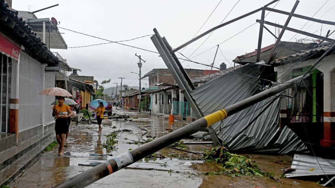 Un grupo de mujeres pasa por los daños en una calle como resultado del huracán John en San Marcos, Estado de Guerrero, México, el 24 de septiembre de 2024. (Foto: FRANCISCO ROBLES/AFP via Getty Images).