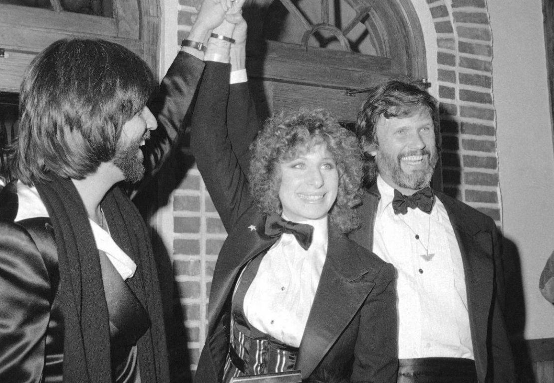 El productor Jon Peters, de izquierda a derecha, Barbra Streisand y Kris Kristofferson aparecen en un preestreno de la película "A Star is Born", el 23 de diciembre de 1976, en Nueva York. Crédito: Suzanne Vlamis/AP.