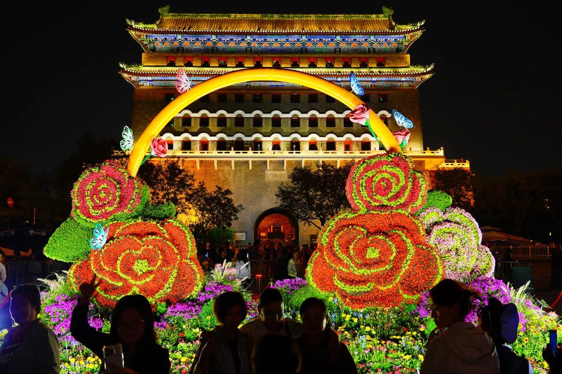 Los turistas visitan una antigua puerta de la ciudad de Beijing, China, antes del Día Nacional.