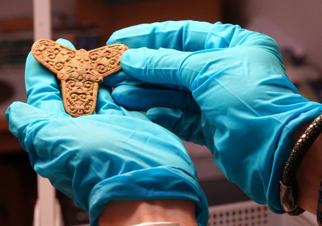 Un conservador del Museo de Odense muestra un broche hallado en un enterramiento de la época vikinga durante una entrevista con periodistas en Odense, Dinamarca, el 25 de septiembre de 2024. Crédito: Tom Little/Reuters