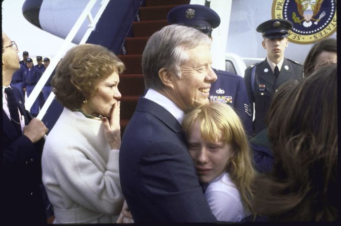 Antes de partir hacia Georgia tras la investidura de Reagan, Carter sostiene a su hija llorando mientras su esposa le lanza un beso en la base aérea Andrews en Maryland.