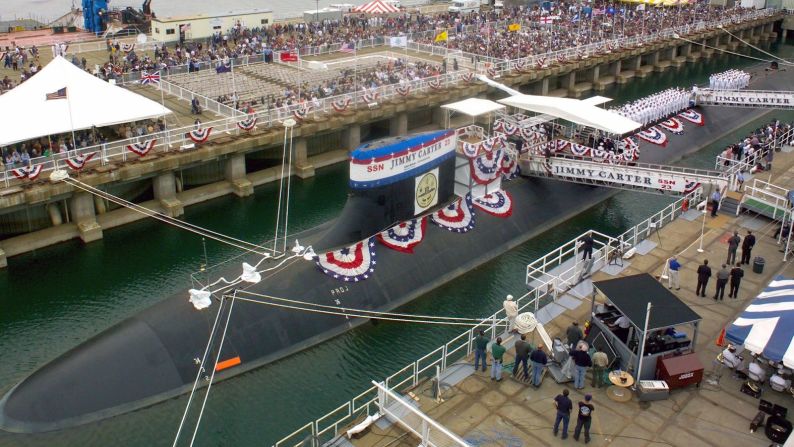 Rosalynn Carter estrella una botella de champán contra la vela del USS Jimmy Carter durante la ceremonia de bautizo del submarino en Connecticut en junio de 2004.