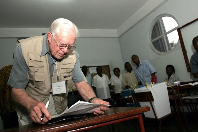 Carter revisa sus notas mientras observa un centro de votación en Maputo, Mozambique, en diciembre de 2004. Desde 1989, el Centro Carter ha estado observando elecciones en todo el mundo para determinar su legitimidad. La organización sin fines de lucro fue fundada por Carter y su esposa para promover los derechos humanos en todo el mundo.