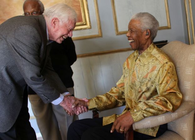 Carter saluda al líder sudafricano Nelson Mandela en Johannesburgo en mayo de 2010.