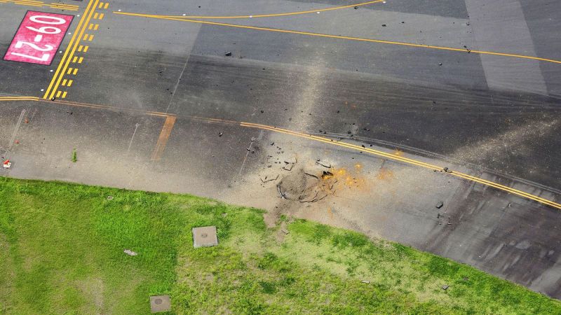 An American World War II bomb explodes at a Japanese airport, leaving a large crater