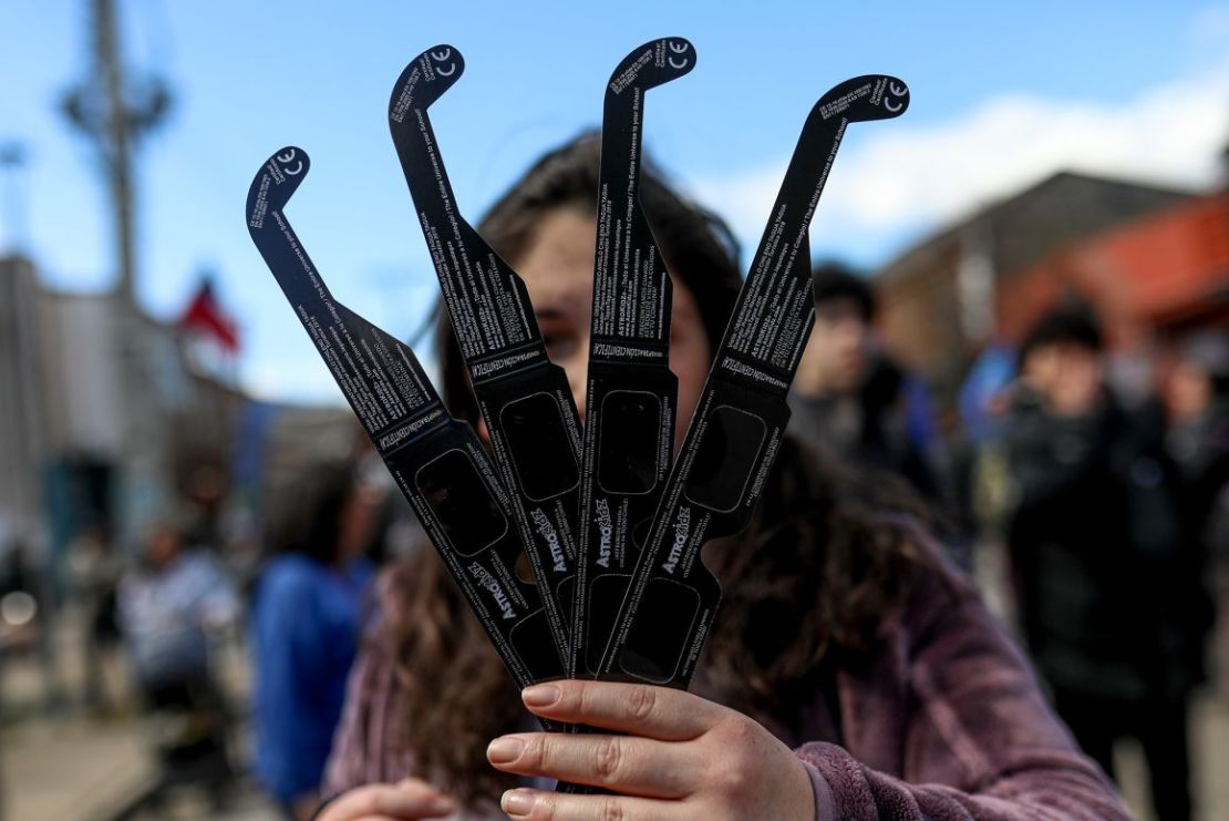 Una mujer distribuye gafas para el eclipse solar en Coyhaique, Chile. Crédito: Lucas Aguayo/picture alliance/Getty Images