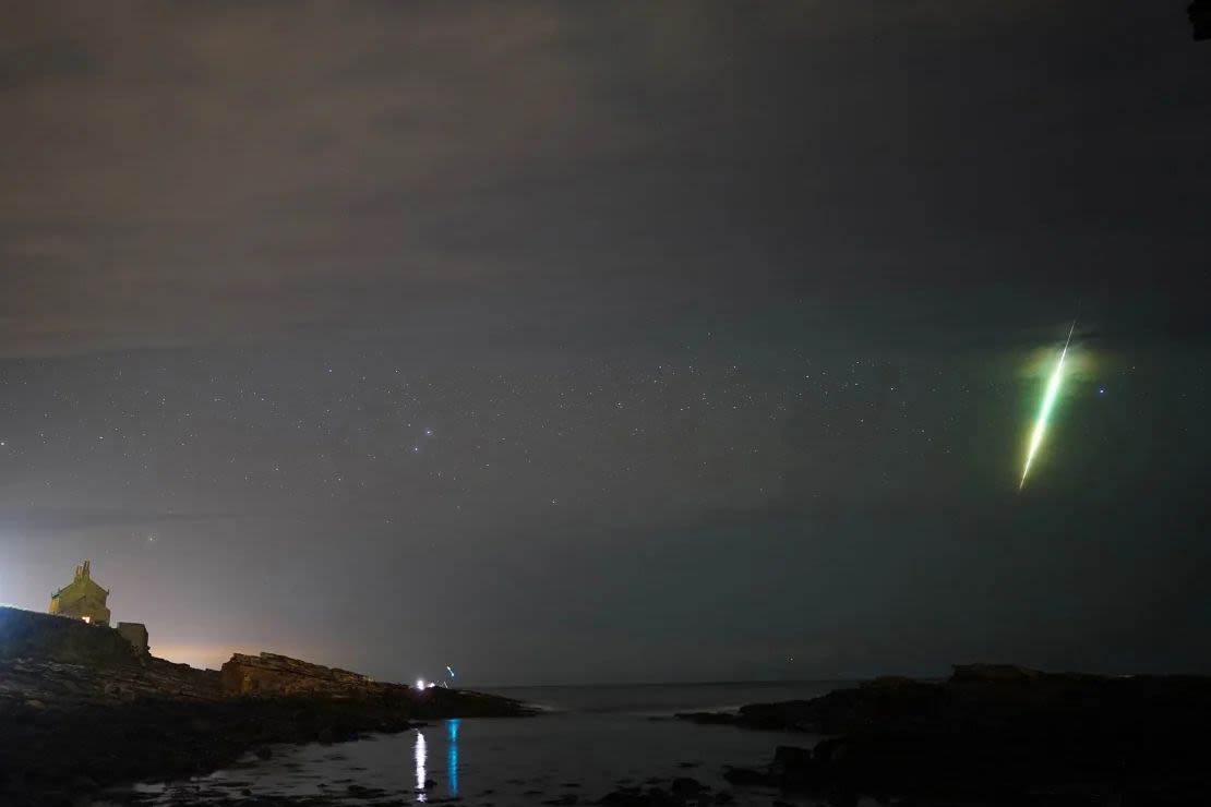 Un meteoro cruza el cielo durante la lluvia de meteoritos Dracónidas, vista sobre las rocas Howick en Northumberland, en el noreste de Inglaterra, en octubre de 2021. Owen Humphreys/PA Media/ARCHIVO