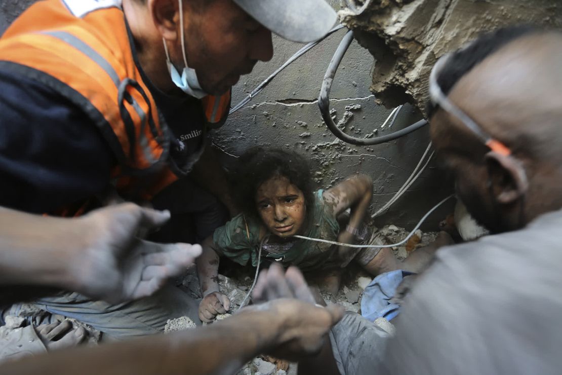 Los equipos de rescate intentan sacar a una niña de entre los escombros de un edificio destruido por los ataques aéreos israelíes en el campo de refugiados de Jabalya, al norte de Gaza. Se cree que miles de personas están desaparecidas bajo los escombros. Crédito: Abed Khaled/AP