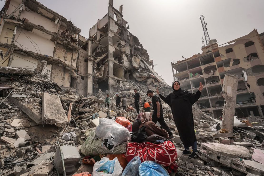 Unas personas miran entre los escombros de unos edificios en abril en el campo de refugiados de Nuseirat, en el centro de Gaza, una zona densamente poblada que albergaba a decenas de miles de personas antes de la guerra. Crédito: AFP/Getty Images