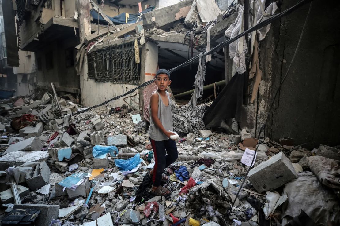 Un niño camina entre los escombros de una casa dañada por los bombardeos israelíes en el campo de Nuseirat, en el centro de Gaza, en julio. Crédito: Majdi Fathi/NurPhoto/AP