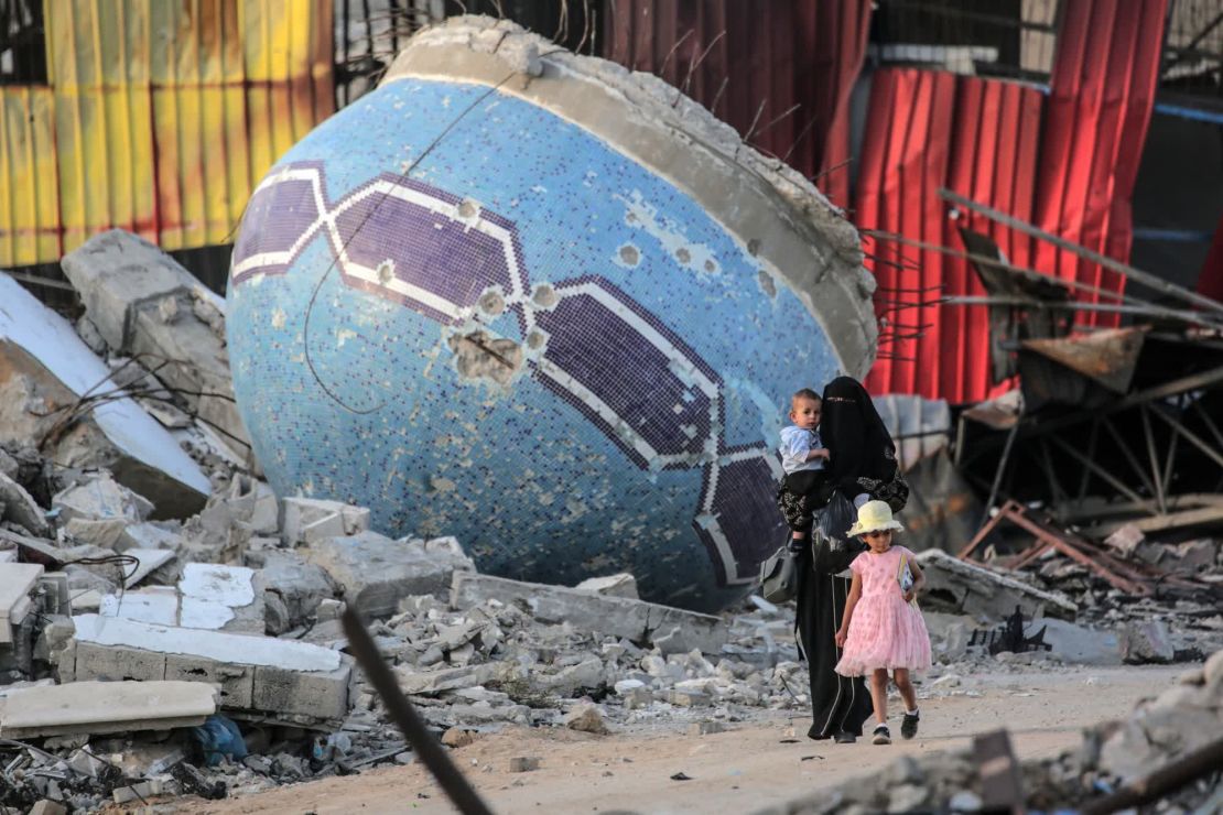 Una mujer y dos niños pasan por una calle de Khan Younis junto a una mezquita arrasada, una de las 825 dañadas o destruidas en Gaza, según la Oficina de Medios de Comunicación del Gobierno de Gaza. Crédito: AFP/Getty Images