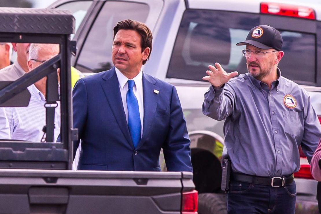 El gobernador de Florida, Ron DeSantis, recibe una visita del director de la División de Gestión de Emergencias de Florida, Kevin Guthrie, mientras habla de la zona de maniobras de maquinaria pesada en el Florida Horse Park de Ocala, Florida, el 8 de octubre de 2024, antes de una rueda de prensa sobre el impacto que tendrá el huracán Milton en el estado de Florida. Crédito: Doug Engle/Ocala Star-Banner/USA Today Network/Imagn