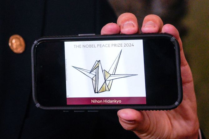 El jefe del Comité Nobel Noruego, Jorgen Watne Frydnes, sostiene un teléfono móvil que muestra el logotipo de la organización japonesa Nihon Hidankyo, ganadora del Premio Nobel de la Paz 2024, durante una conferencia de prensa en el Instituto Nobel Noruego en Oslo, Noruega, en El Premio Nobel de la Paz 2024 fue otorgado al grupo antinuclear japonés Nihon Hidankyo, un movimiento de base de sobrevivientes de las bombas atómicas de Hiroshima y Nagasaki, también conocido como Hibakusha. El grupo, fundado en 1956, recibió el honor "por sus esfuerzos para lograr un mundo libre de armas nucleares y por demostrar mediante testimonios de testigos que las armas nucleares nunca deben volver a utilizarse", dijo Jorgen Watne Frydnes.