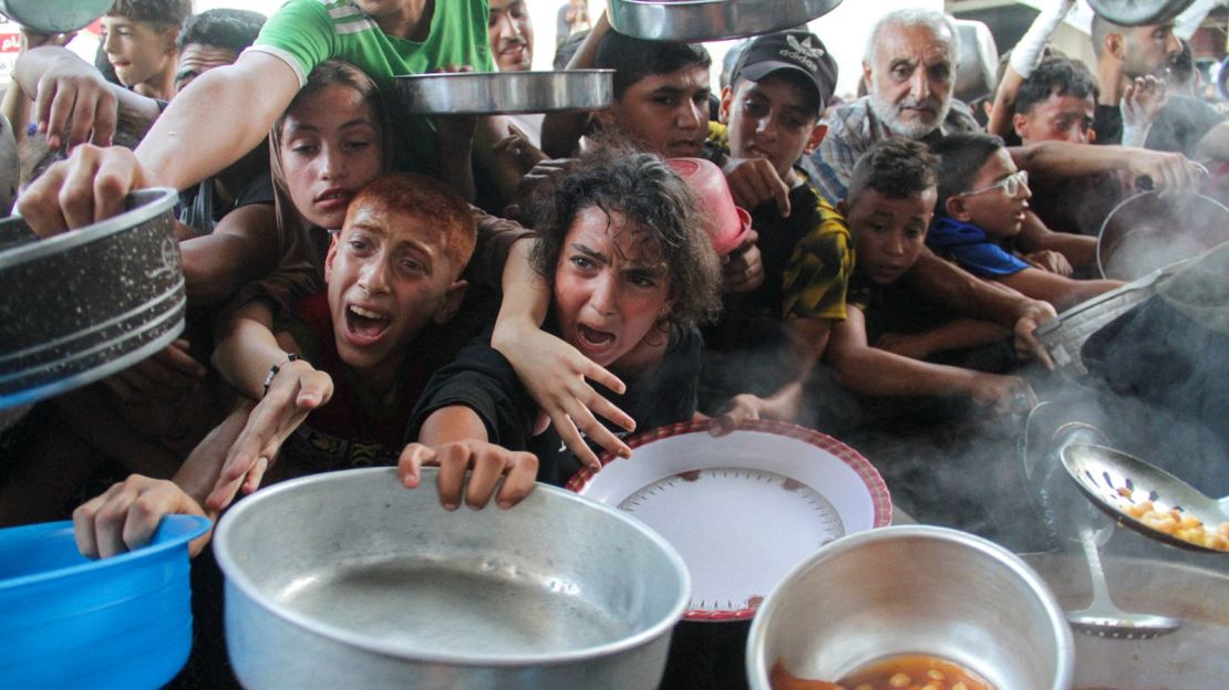 Palestinos reciben alimentos cocinados por una cocina de caridad en el norte de Gaza, 11 de septiembre de 2024.