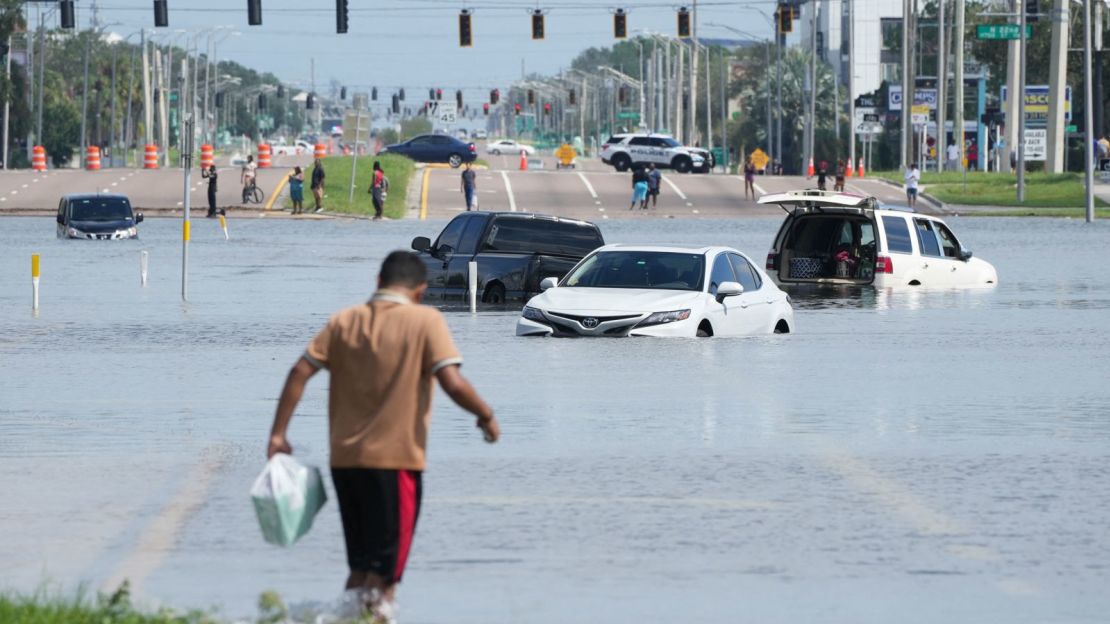 Un joven camina junto a vehículos inundados en Tampa, Florida, tras el paso del huracán Milton el 10 de octubre de 2024.