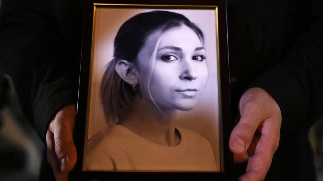 A colleague of Ukrainian journalist Victoria Roshchina holds a photo of her during a memorial event in Kiev.