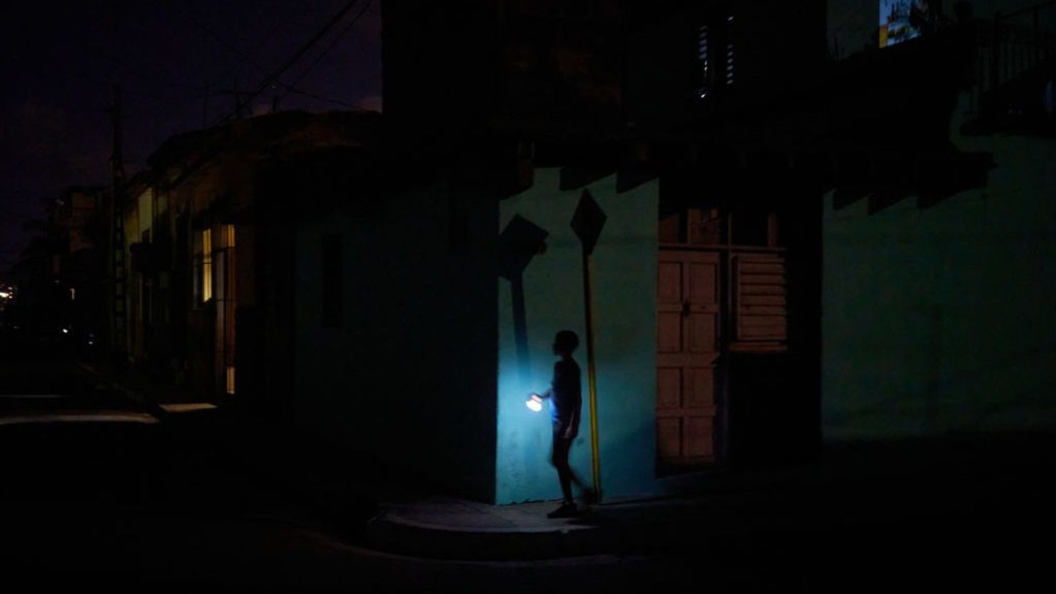 Un niño residente de Pueblo Nuevo camina iluminado con la linterna de un teléfono celular durante un apagón nocturno de 6 horas en la provincia de Matanzas, Cuba, el 23 de mayo de 2024. Crédito: ANTONIO LEVI/AFP vía Getty Images.