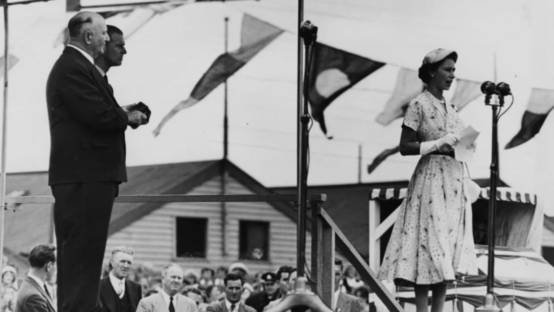 La reina Isabel II habla con los militares desde el escenario, observada por el duque de Edimburgo (detrás, a la derecha) en el Newcastle Sports Ground, Australia, el 9 de febrero de 1954.