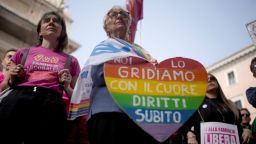 Una mujer muestra un cartel que dice "lo gritamos desde el corazón, ahora derechos" durante una conferencia de prensa a favor de la gestación subrogada en Roma, el martes 15 de octubre de 2024.