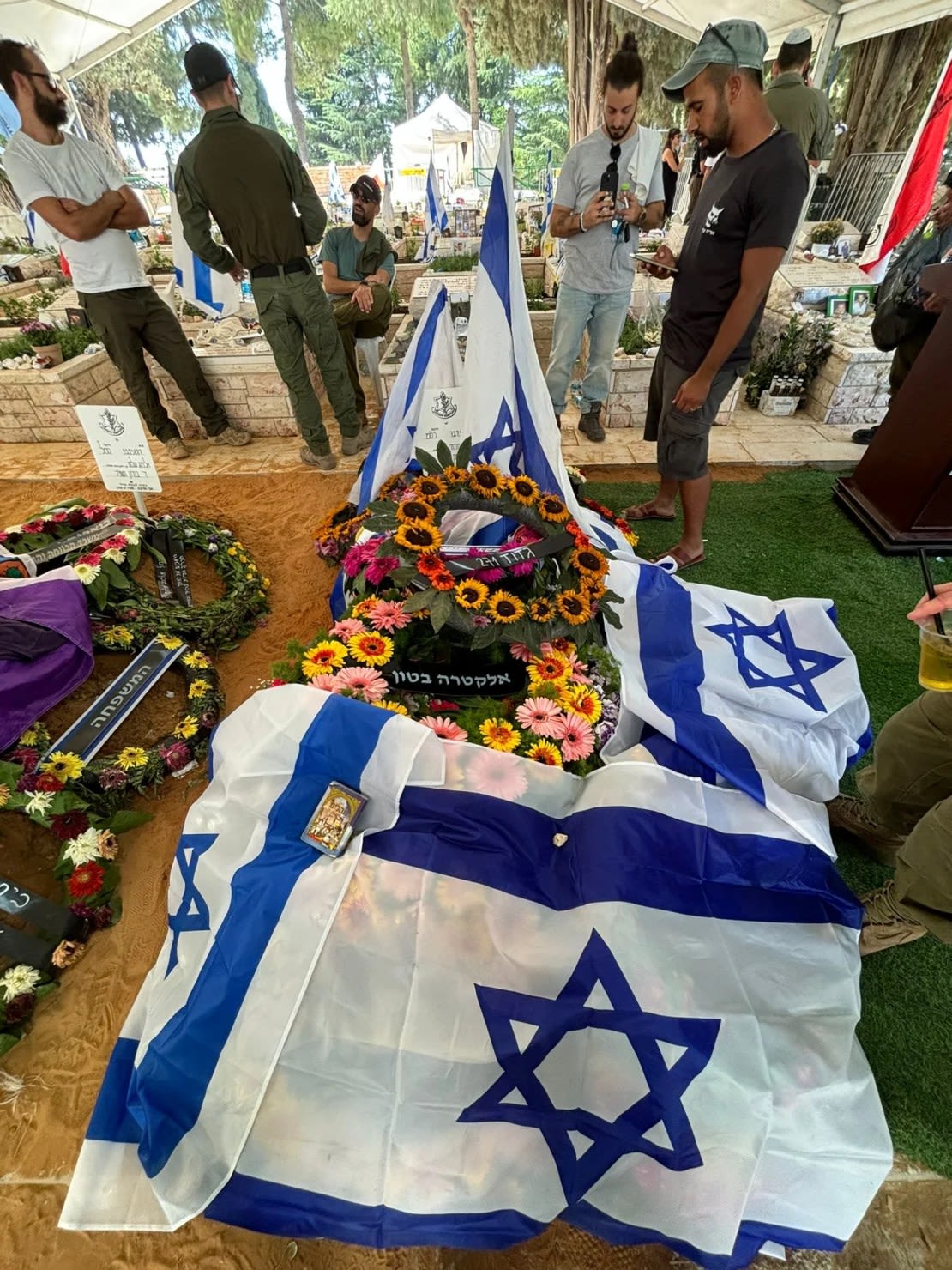 La tumba de Eliran Mizrahi, adornada con flores y la bandera israelí durante su entierro militar en Jerusalén el 13 de junio de 2024.