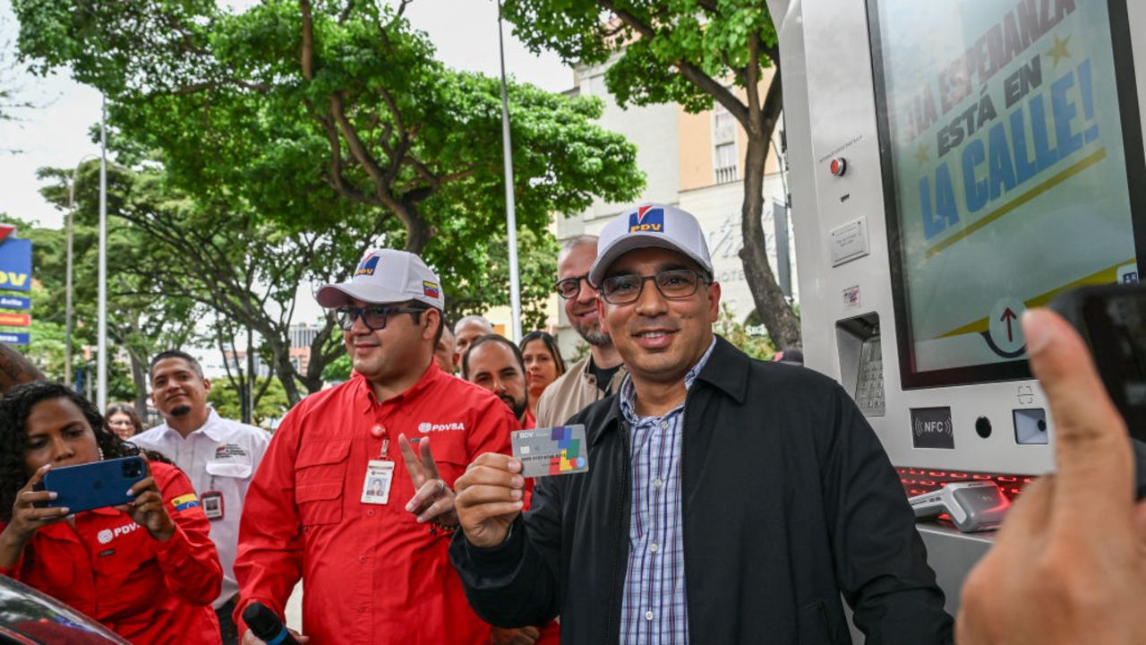 Venezuela's Oil Minister and President of the Venezuelan state oil company PDVSA, Pedro Tellechea, smiles with a bank card in his hands during a press conference at a petrol station in Caracas on June 14, 2024. Venezuela is approaching to produce a million crude oil barrels per day, a figure not reached for more than five years in the midst of US sanctions and multiple allegations of corruption in the industry, according to Tellechea. (Photo by Juan BARRETO / AFP)