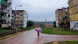 A child walks carrying an umbrella in Matanzas, Cuba, on October 18, 2024, during a nationwide blackout caused by a grid failure. Technical breakdowns, fuel shortages and high demand have caused the country's thermoelectric power plants to constantly fail, forcing the government to declare an energy emergency and take measures such as closing schools and factories.