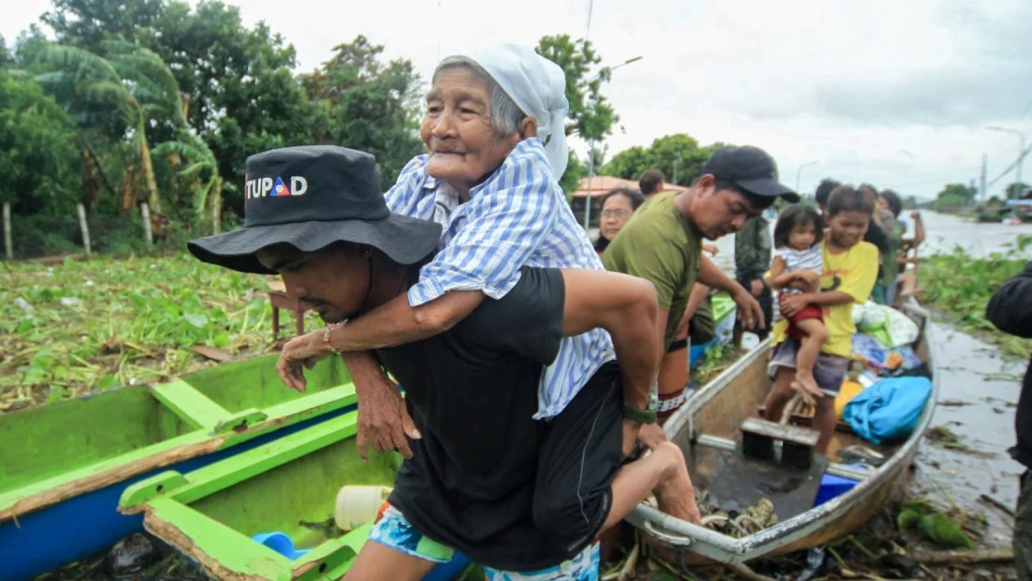 Una anciana es llevada por un rescatista voluntario mientras los residentes son evacuados a terrenos más seguros en el municipio de Bato, provincia de Camarines Sur, al sur de Manila, Filipinas, el 23 de octubre de 2024.