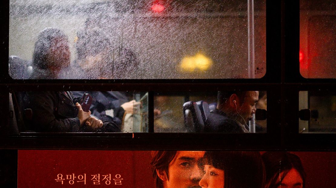 Los viajeros viajan en un autobús mientras llueve en Seúl, Corea del Sur, el 22 de octubre de 2024.