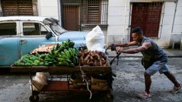 A man pushes a cart full of vegetables down a Havana street on October 22, 2024. Seventy percent of Cuba's population now has power, four days after a nationwide blackout triggered by the collapse of the island's largest power plant, and as the country recovers from Hurricane Oscar, the government said Tuesday. (Photo by YAMIL LAGE / AFP)