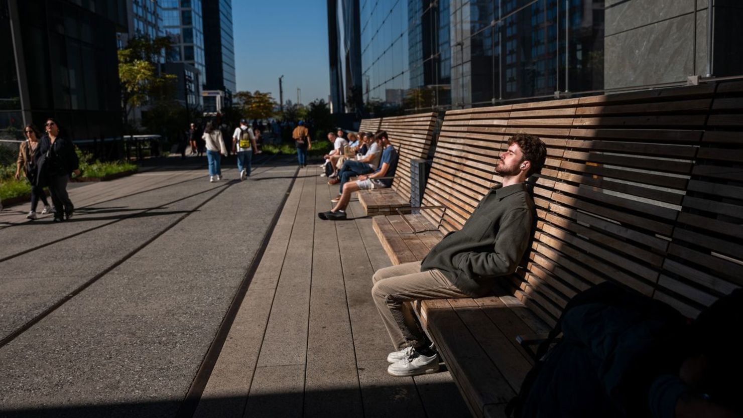 La gente descansa al sol a lo largo del High Line en un día soleado e inusualmente cálido en Nueva York el 21 de octubre de 2024. Crédito: Spencer Platt/Getty Images
