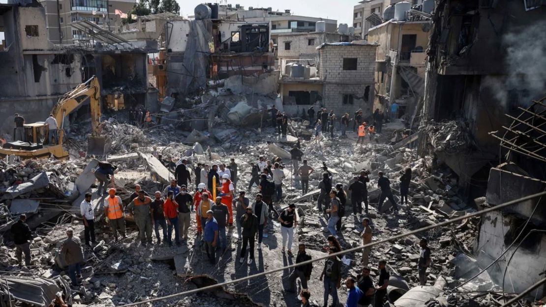 Trabajadores de emergencia y lugareños están en el sitio de un edificio demolido tras un ataque israelí cerca del Hospital Universitario Rafik Hariri en Beirut, Líbano, el 22 de octubre de 2024.