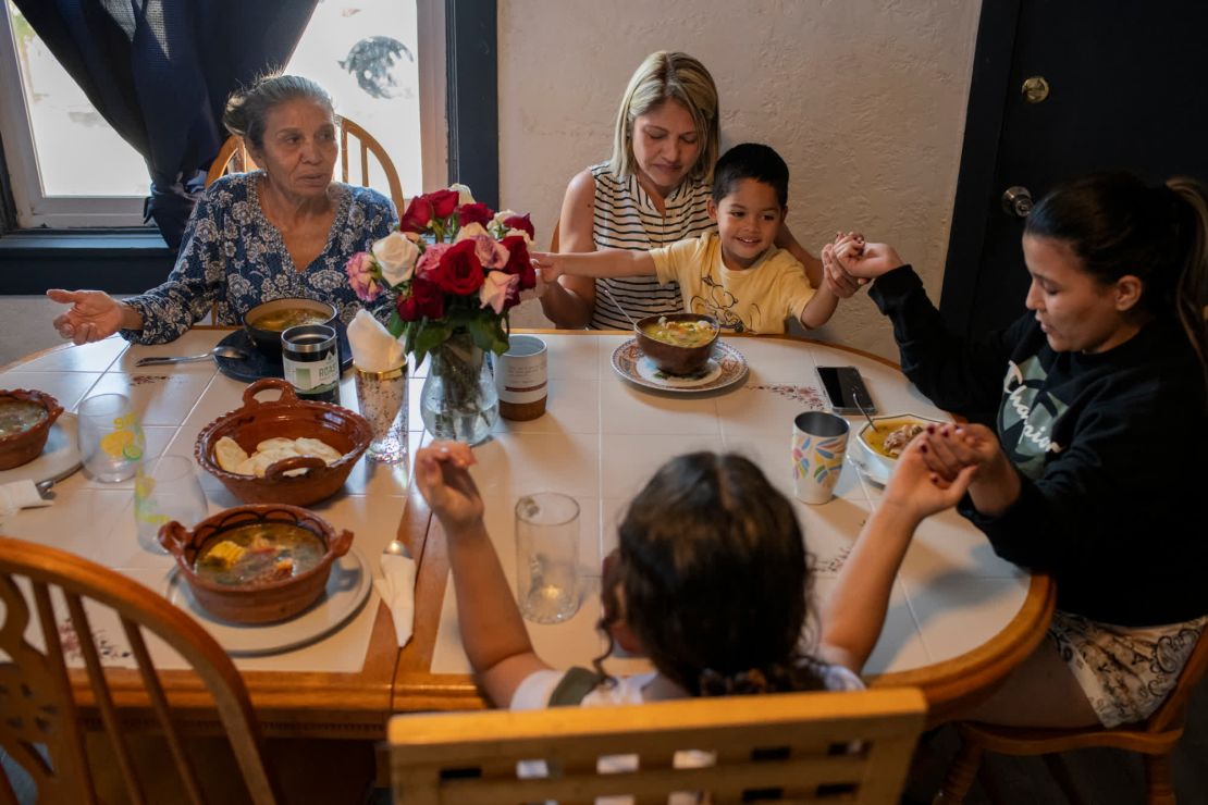 Yuri Alarcón, a la derecha, dirige una oración antes de que su familia coma una comida dominical. "Gracias, Padre. Por favor protege a todos en esta casa, y danos luz, felicidad y amor".