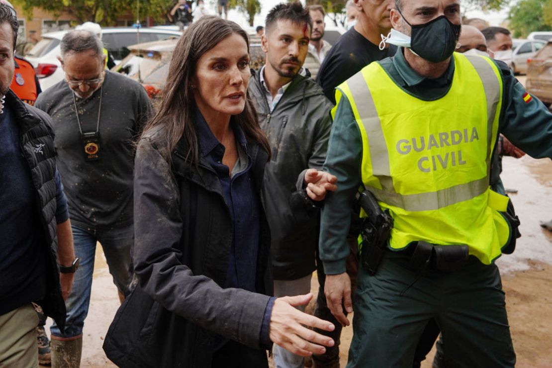 La reina Letizia de España, con manchas de barro en la cara, se acerca a hablar con un residente del pueblo durante la visita de la pareja real española a Paiporta.