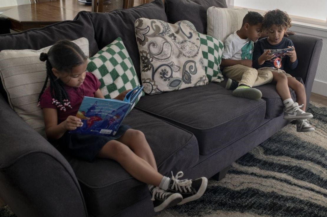 Desde la izquierda, Laura Sanzo, de 5 años, lee un libro junto a su hermano, Mathias Sanzo, de 5 años, y su primo, Santiago Castellano, de 6 años, después del colegio. Crédito: Rachel Woolf para CNN