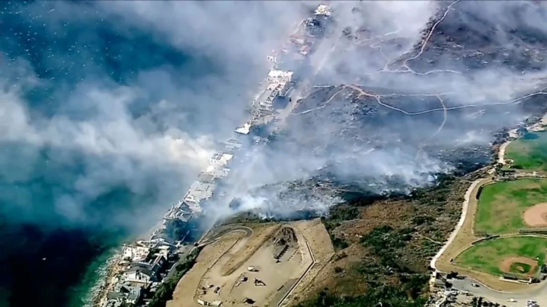 Los equipos del Departamento de Bomberos del Condado de Los Ángeles se apresuraron a contener un incendio alimentado por ráfagas de viento erráticas que empujaron las llamas a través de la maleza seca cerca de Broad Beach a lo largo de Pacific Coast Highway en Malibu este miércoles.