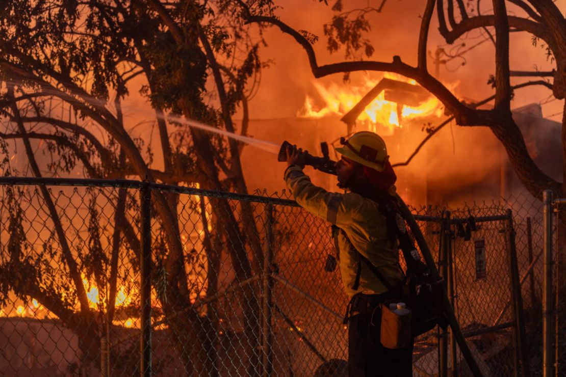 Un bombero del condado de Los Ángeles lucha contra las llamas mientras una casa arde en el incendio Mountain el 6 de noviembre de 2024 en Camarillo, California.