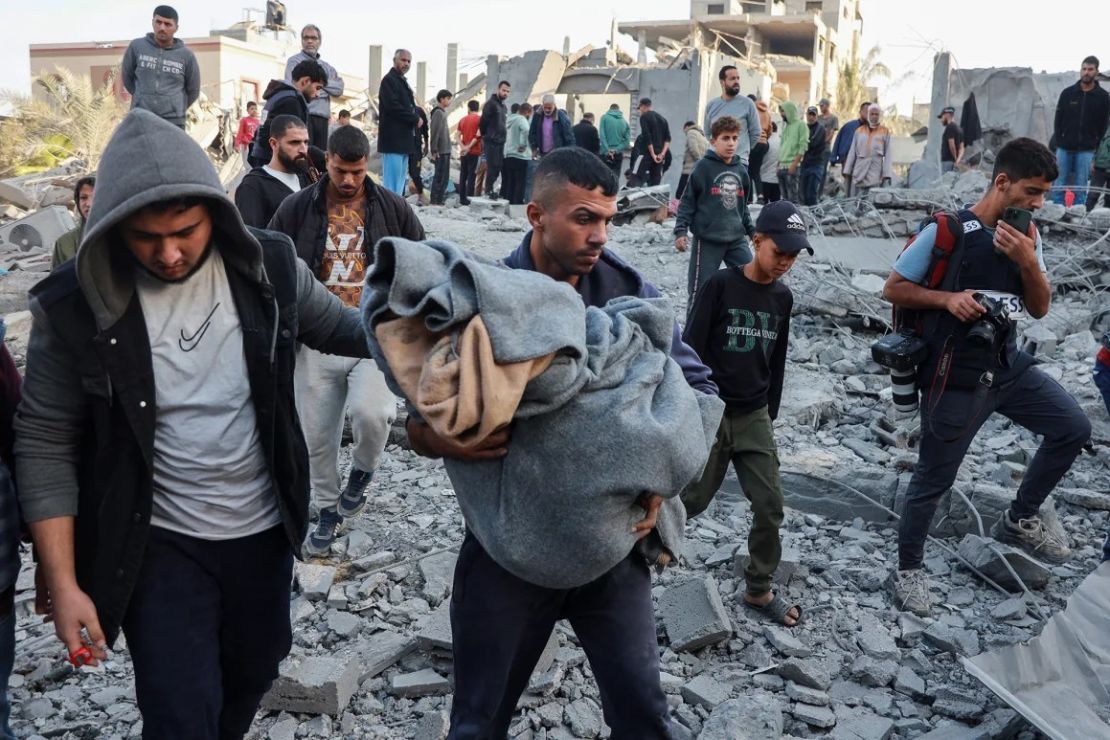 Un hombre lleva el cuerpo de un palestino muerto por un ataque aéreo israelí contra una casa en Nuseirat, en el centro de Gaza, el 7 de noviembre. Abdel Hakeem Khaled/Reuters