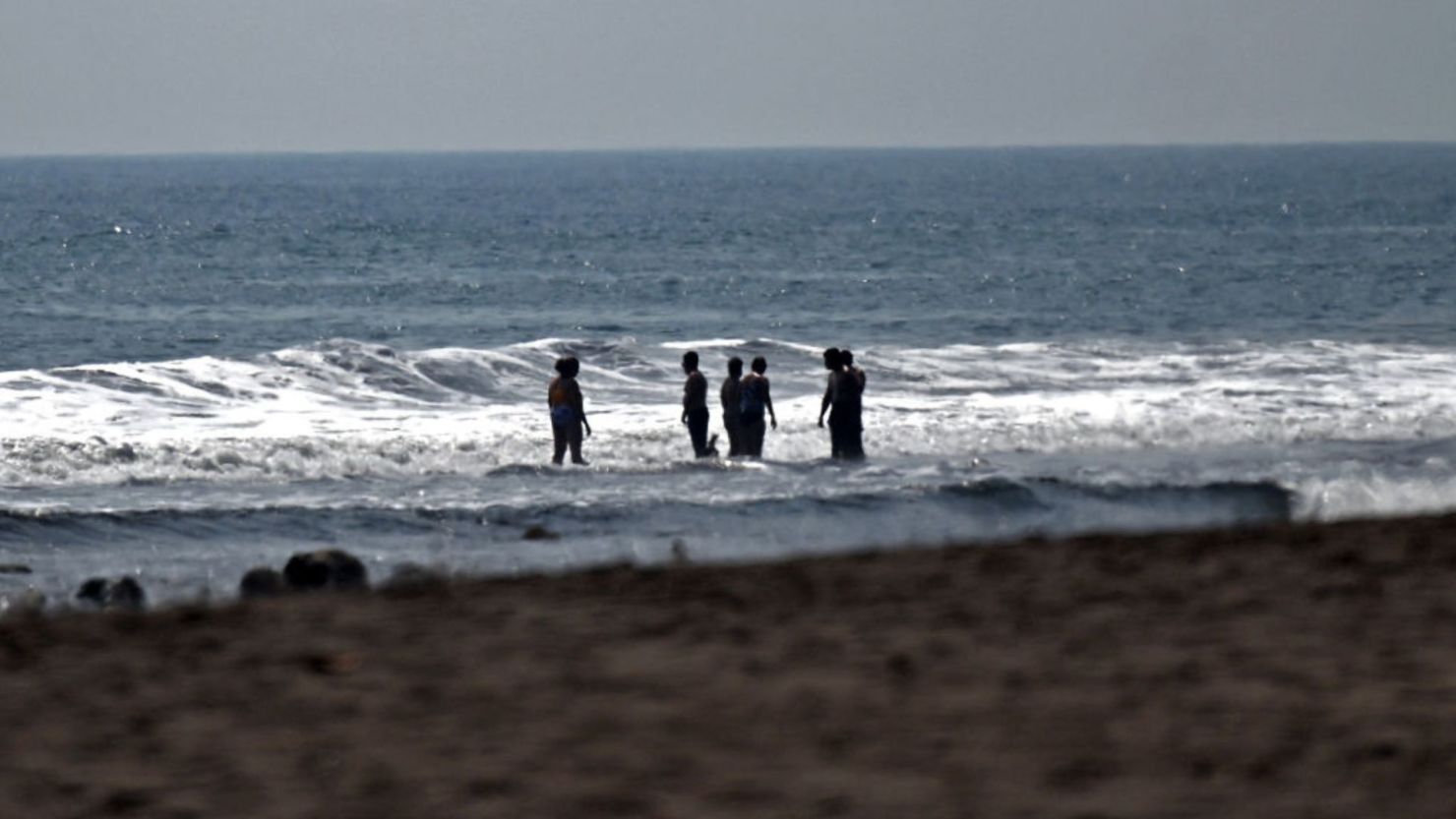 Los turistas se bañan en la playa El Zonte, El Salvador, 16 de marzo de 2024. Crédito: MARVIN RECINOS/AFP vía Getty Images