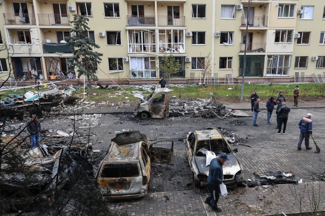 Los residentes se reúnen junto a sus coches destruidos y un edificio de apartamentos dañado en Odessa, Ucrania, el 9 de noviembre.