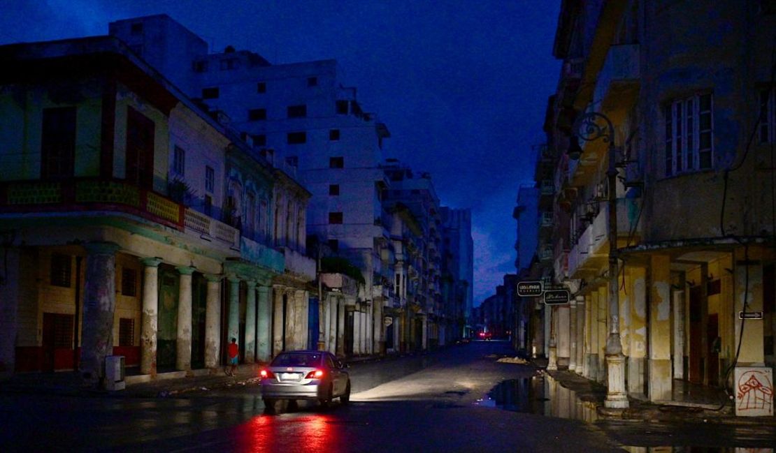 Un automóvil circula por una calle durante un apagón nacional causado por una falla en la red en La Habana, el 19 de octubre de 2024. Las fallas técnicas, la escasez de combustible y la alta demanda han provocado que las centrales termoeléctricas del país fallen constantemente, lo que obligó al gobierno a tomar medidas como cerrar escuelas y fábricas.