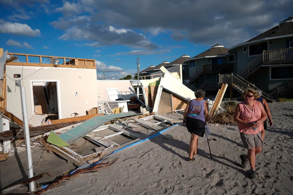 Neighbors look at what remains of a home destroyed by Hurricane Milton's storm surge at a 55+ mobile home community on Manasota Key in Englewood, Fla., Sunday, Oct. 13, 2024. Rebecca Blackwell/AP .