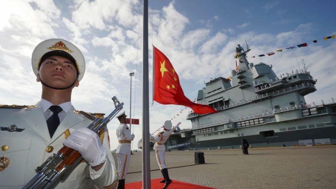 La guardia de honor china iza la bandera de China durante la ceremonia de puesta en servicio del portaaviones de propulsión convencional Shandong de China en un puerto naval en Sanya, en la provincia de Hainan, al sur de China, el 17 de diciembre de 2019.