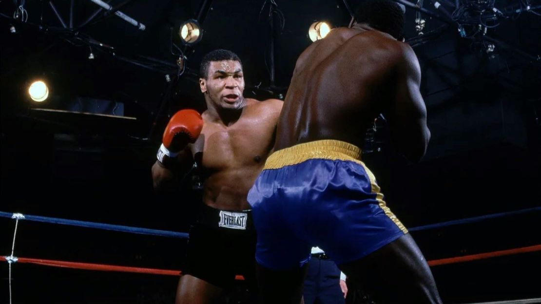 Tyson (izquierda) irrumpió en la escena del boxeo en 1985 cuando tenía 18 años. Aquí se le ve derrotando a Mark Young (derecha) en el Coliseo de Latham en su decimoquinta pelea profesional. Manny Millan/Sports Illustrated/Getty Images