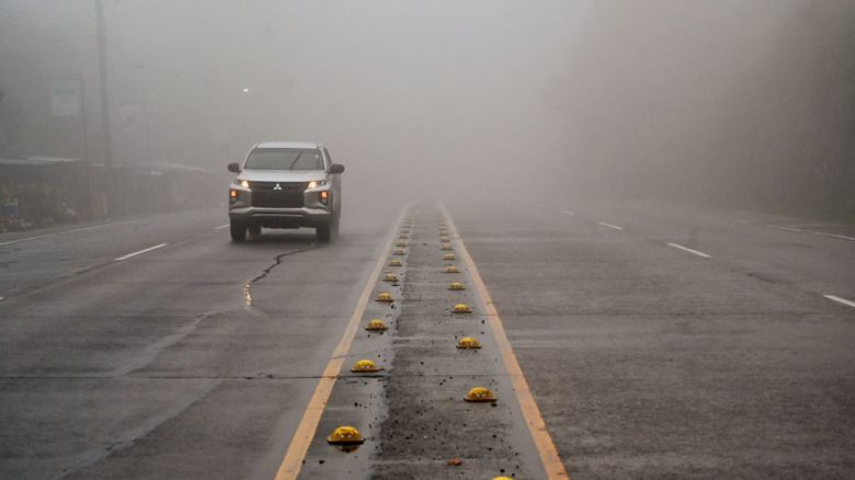 A car drives through heavy fog ahead of the arrival of tropical storm Sara in Siguatepeque, Honduras on November 14, 2024. Honduran government declared a red alert in four Caribbean departments ahead of the landfall of tropical storm Sara, President Xiomara Castro and the Ministry of Risk Management reported. (Photo by Orlando SIERRA / AFP)