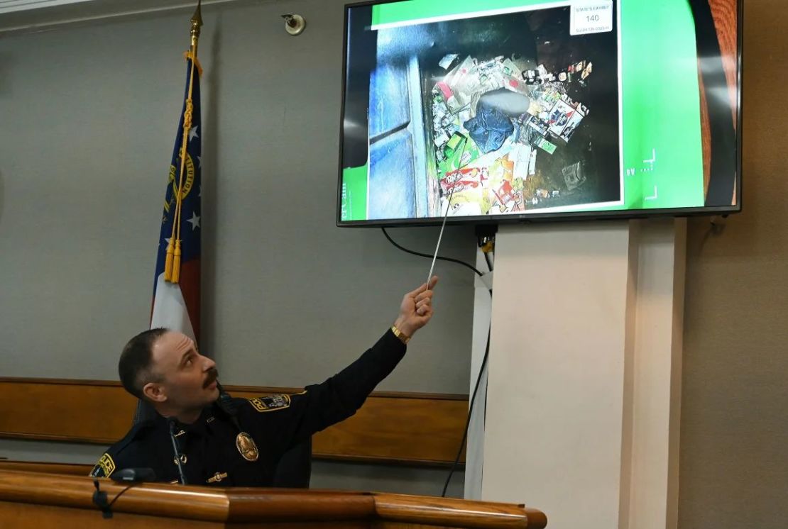 El agente de policía del condado de Athens-Clarke, Zachary Davis, señala la chaqueta que recogió de un contenedor de basura mientras testifica durante el juicio de Jose Ibarra el 15 de noviembre de 2024. Crédito: Hyosub Shin/Pool/Atlanta Journal-Constitution/AP